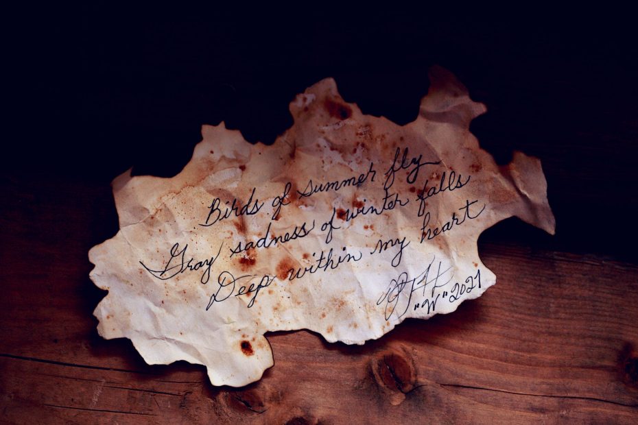 white burnt paper with text on brown wooden table